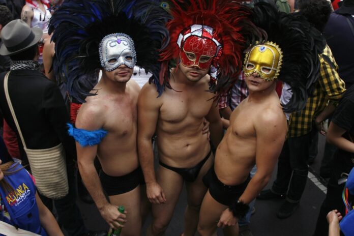 Three revellers attend the annual Gay Pride parade in Bogota
