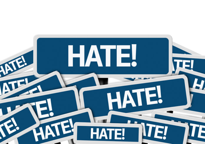 Hate! written on multiple blue road sign
