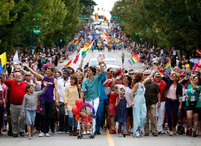 Canada's Prime Minister Justin Trudeau waves to the crowd while walking in the Vancouver Pride Parade with his family in Vancouver