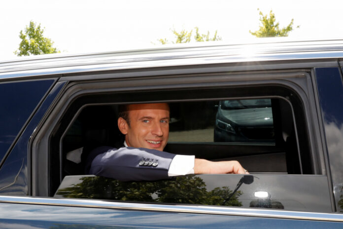 French President Emmanuel Macron leaves a recreational centre for children following a visit, in Moisson