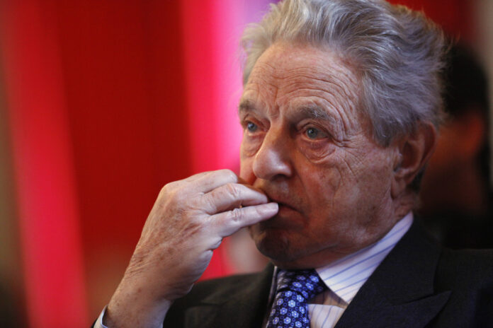 Soros listens to economists speaking at