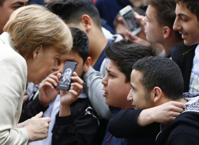 A student of the Roentgen school takes a selfie picture with German Chancellor Merkel during her visit to the school in Berlin