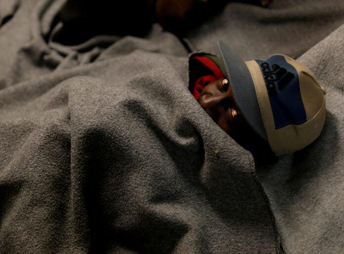 FILE PHOTO: A migrant rests on the migrant search and rescue ship Sea-Watch 3 off the coast of Malta in the central Mediterranean Sea