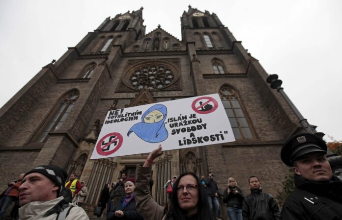 A demonstrator holds a banner during an anti-immigrants rally in Prague