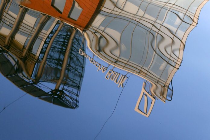 The logo of Deutsche Bank is reflected in waters of the Moskva river in Moscow