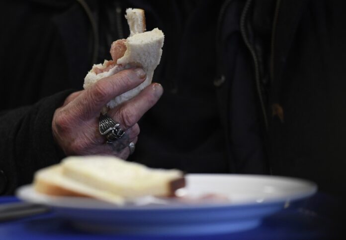 A homeless man, named John, eats a meal at a seasonal shelter for the homeless run by the charity Shelter in a school in north London