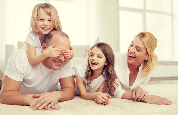 family, children and home concept - smiling family with and two