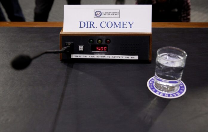 A microphone and glass of water stand ready for FBI Director James Comey before a Senate Intelligence Committee hearing on “Russia’s intelligence activities