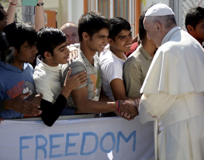 Pope Francis greets migrants