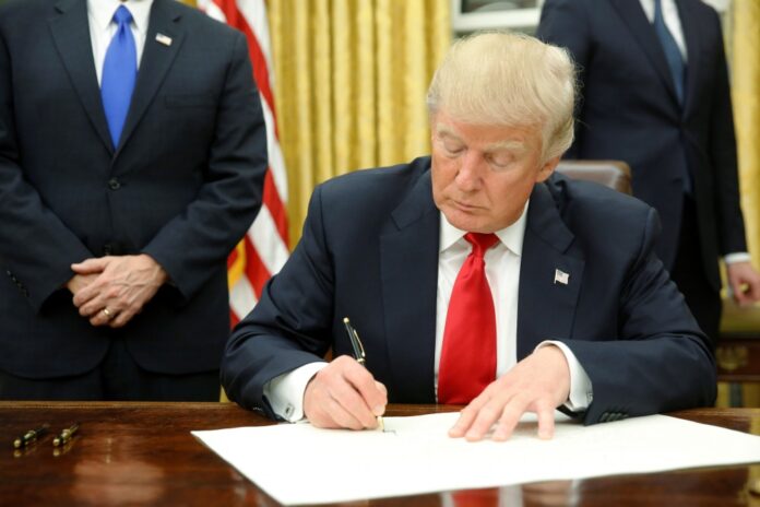 Trump signs his first executive orders in the Oval Office in Washington