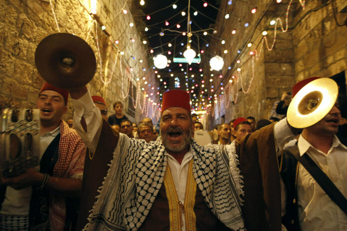 Palestinian musicians perform in Jerusalem's Old City during celebrations to mark the breaking of fast on the second day of the holy month of Ramadan