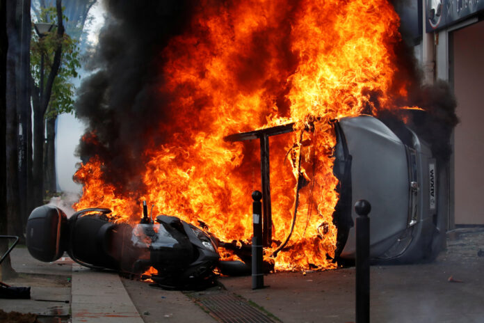 A car burns outside a Renault automobile garage during clashes at the May Day labour union march in Paris