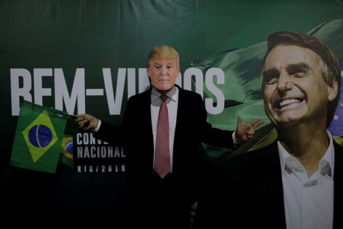 FILE PHOTO: A supporter of Federal deputy Bolsonaro wears a mask of U.S. President Trump before the national convention of the Party for Socialism and Liberation (PSL) where he is to be formalized as a candidate for the Presidency of the Republic