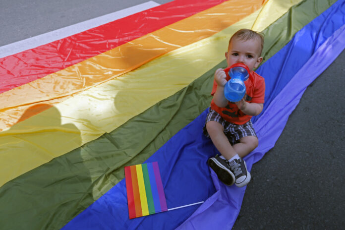 A child drinks water on the rainbow flag during Romania's gay community Gay Fest 2014 pride parade in Bucharest
