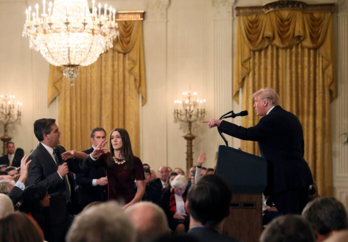 FILE PHOTO: A White House staff member reaches for the microphone held by CNN's Jim Acosta as he questions U.S. President Donald Trump during a news conference in Washington