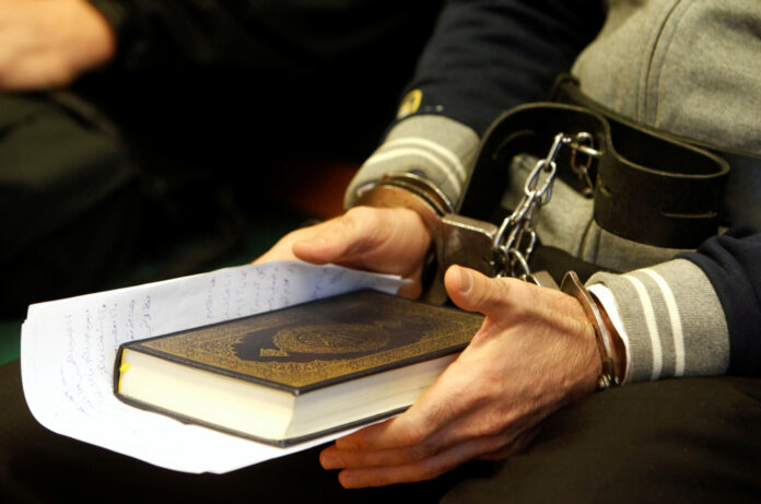 Syrian-Cypriot Hamed holds a copy of the Holy Quran as he listens to a judge sentence in Szeged
