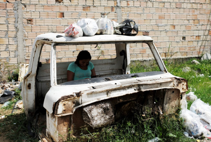 Venezuelan woman writes on her mobile phone as she sits inside the cabin of a car in Pacaraima